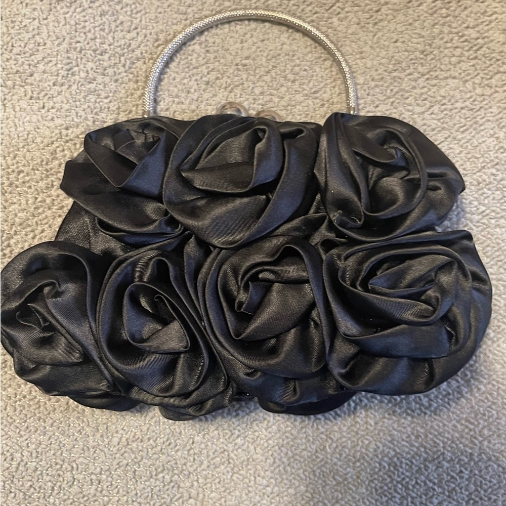 Black flower embellished clutch with silver chain as shoulder strap included.